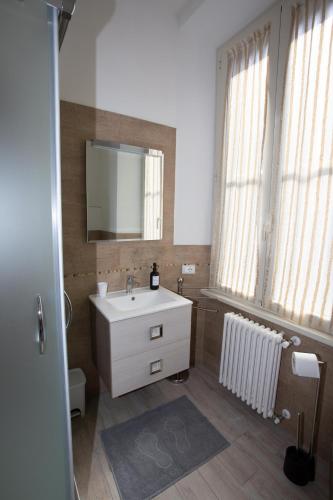 a bathroom with a sink and a mirror and windows at La finestra sul pincio in Civitavecchia