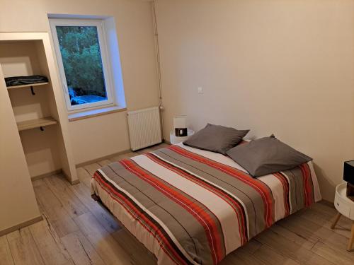 una camera da letto con un letto con due cuscini e una finestra di Gîte La Dolce Vita a Saint-Félix-Lauragais