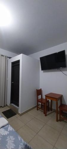 a room with a tv and a table and a chair at Hospedaje Moralillos in Yurimaguas