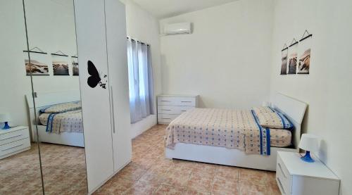 una camera bianca con 2 letti e uno specchio di Via del Mare a Termoli