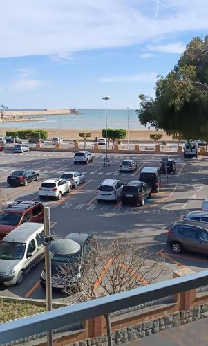 um parque de estacionamento com carros estacionados junto à praia em Andmar Beach Apartamento em Peníscola