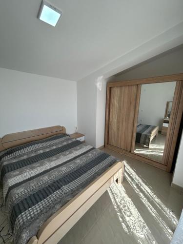 a bedroom with a bed and a large mirror at Apartmani Planinska Idila in Bar