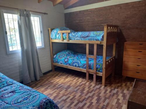 a bedroom with two bunk beds in a room at somos "EL FIN DEL AFAN" 2, casa con vistas a las sierras in Potrero de los Funes