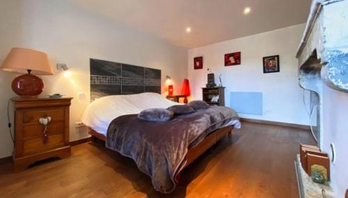 une chambre avec un grand lit et un parquet dans l'établissement Maison de caractère en habitat partagé, à Tourlaville