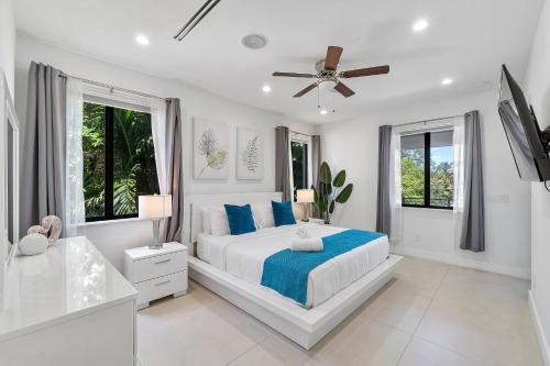 a white bedroom with a bed and a ceiling fan at Mins to Las Olas Private Pool BBQ Grill Luxurious in Fort Lauderdale