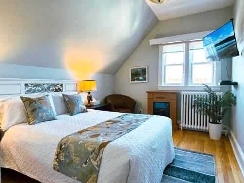 - une chambre avec un grand lit et une fenêtre dans l'établissement The Eden Hall Inn, à Charlottetown