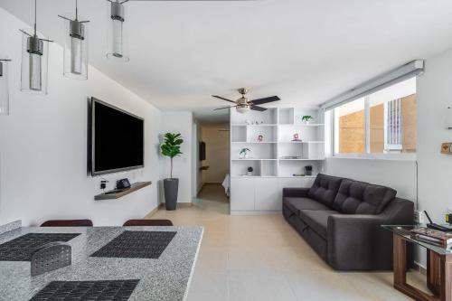 a living room with a couch and a tv at MS Deslumbrante Suite Centrico A11 in Casa Blanca La Corregidora
