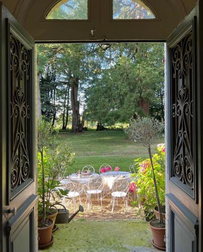 Une porte ouverte s'ouvre sur une terrasse avec une table et des chaises. dans l'établissement Les séquoias géants, à Saint-Martin-aux-Arbres