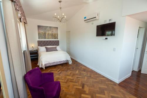 a bedroom with a bed and a purple chair at La Santa Hotel Boutique in Mendiolaza