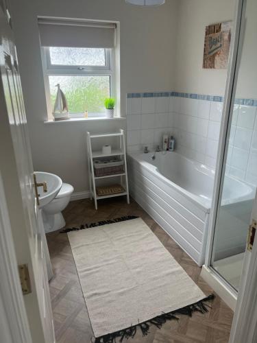 uma casa de banho com uma banheira, um WC e um lavatório. em Port Miller em Portstewart