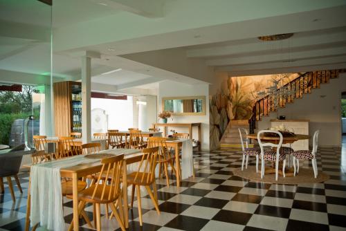 a restaurant with wooden tables and chairs on a checkered floor at La Santa Hotel Boutique in Mendiolaza