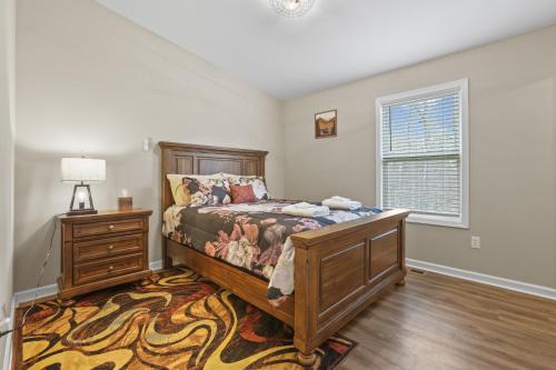 een slaapkamer met een bed, een dressoir en een raam bij Serene Logan Retreat with Private Hot Tub and Fire Pit in Logan