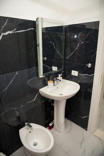 a bathroom with a sink and a toilet and a mirror at Vila Stefano Stepa in Tragjas