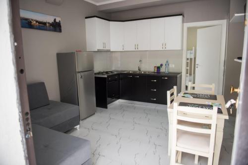 a kitchen with a stainless steel refrigerator and white cabinets at Vila Stefano Stepa in Tragjas