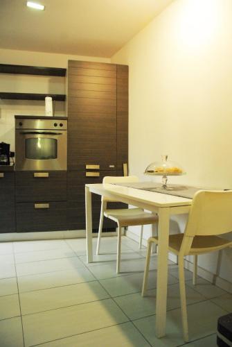 a kitchen with a white table and chairs and a stove at Publiohouse23 in Sulmona