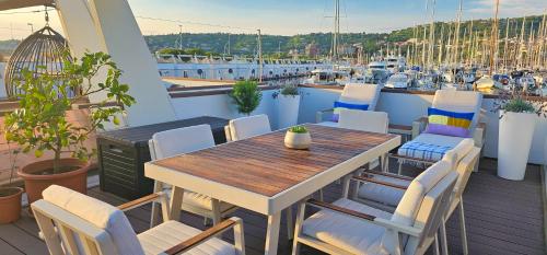 einen Tisch und Stühle auf einem Balkon mit Yachthafen in der Unterkunft Floating Sea house MIRAMARE in Portorož