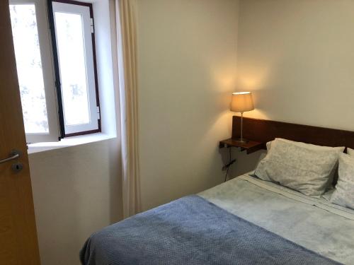 1 dormitorio con cama y ventana en Apartamento 1 Penedo en Sintra