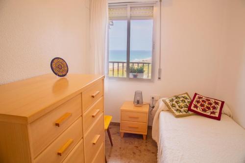 a bedroom with a bed and a dresser and a window at AP Over the Sea in Arenales del Sol