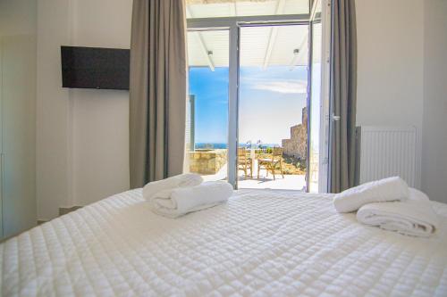 a bedroom with a white bed with towels on it at Summer Villa Barbara ,private pool in Mikonos