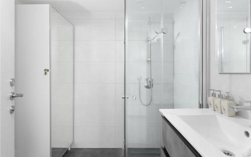 a white bathroom with a shower and a sink at סוויטה עם נוף וצמודה לים במתחם SeaSide היוקרתי עם בריכה - By SEAELO EILAT in Eilat