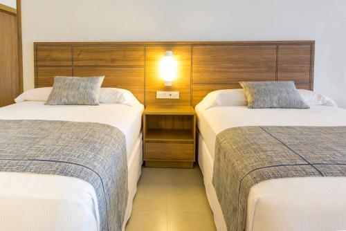 a hotel room with two beds and a night stand at Riu Emerald Bay - All Inclusive in Mazatlán