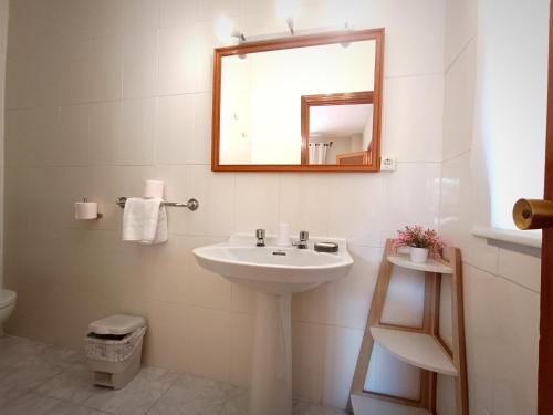 Baño blanco con lavabo y espejo en Hostal Cristina en Chipiona