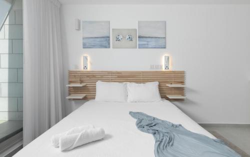a bedroom with a white bed with a headboard at סוויטה עם נוף וצמודה לים במתחם SeaSide היוקרתי עם בריכה - By SEAELO EILAT in Eilat