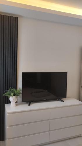 a flat screen tv sitting on top of a white dresser at inas apartments 2 in Lefkímmi