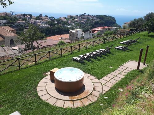 a hot tub in the middle of a field with chairs at Portico Del Paradiso in Scala