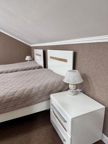 a bedroom with a bed and a nightstand with a lamp at Hotel Korona in Kropyvnytskyi