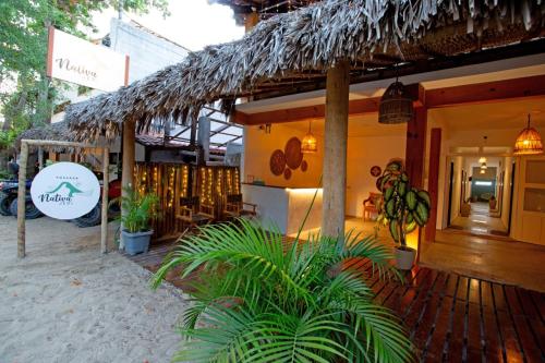 un restaurant sur la plage avec un toit de paille dans l'établissement Pousada Nativa Jeri, à Jericoacoara
