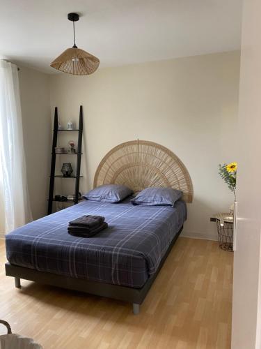 a bedroom with a bed with a blue comforter at Confortable et agréable T1 n•1 in Ussel