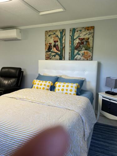 1 dormitorio con 1 cama con almohadas amarillas y azules en WHITEWATER COTTAGE, en Chilliwack