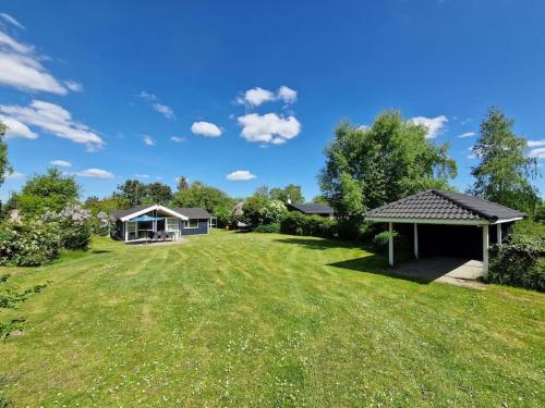 a large yard with a house and a gazebo at Holiday house by a fantastic beach and free WiFi in Slagelse