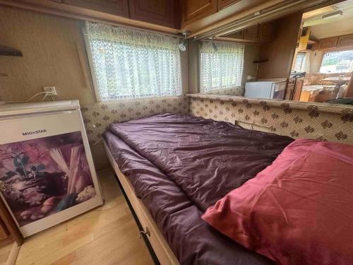 a bed in the back of a tiny house at WOODMOOD Caravan Experience in Leuk