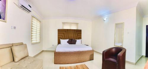 a bedroom with a bed and a couch at Vintage Classic Suites in Lagos