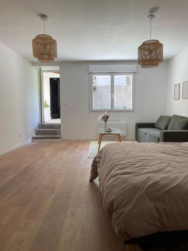 Belle des champs - Loft avec spa في Labruguière: غرفة بيضاء مع سرير وأريكة