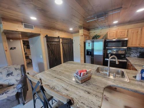a kitchen with a counter with a sink and a refrigerator at Eagles View, Luxury living Amazing Mtn Views! indoor pool & spa in Gatlinburg