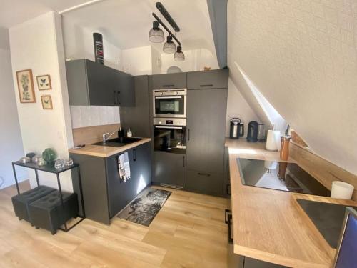 une cuisine avec des appareils en acier inoxydable et un escalier dans l'établissement La douce escapade, Superbe T2, 4 pers - parking, balcon, à Villers-sur-Mer