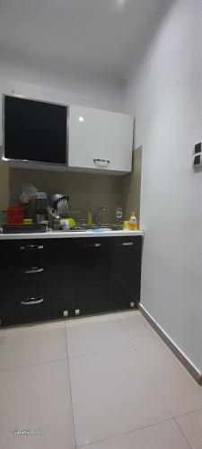 a kitchen with a sink and a tv on the wall at Spid apartman in Obrenovac