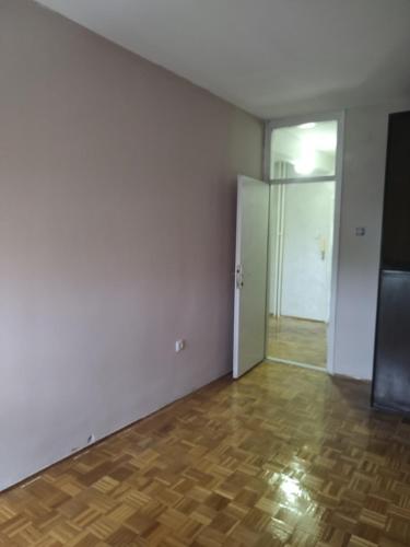 an empty room with a door and a wooden floor at Spid apartman in Obrenovac