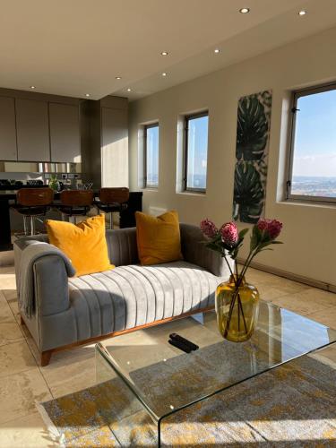 a living room with a couch and a glass table at The Franklin Luxury Apartments in Johannesburg