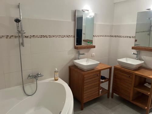 La salle de bains est pourvue d'une baignoire, de 2 lavabos et d'une douche. dans l'établissement Appartement privatif avec extérieur, à Aubignan