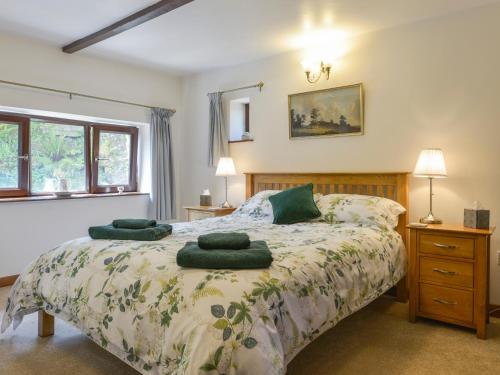 a bedroom with a bed with green towels on it at Buster Barn in Sampford Spiney