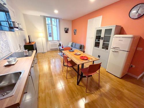 una cucina con tavolo con sedie e frigorifero di Nuovo appartamento Saint Remy a Cagliari