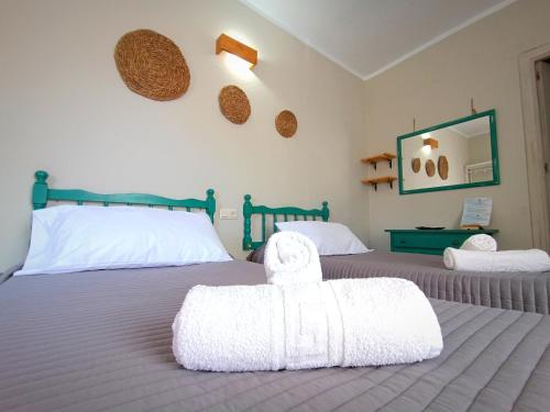 um quarto com 2 camas e lençóis brancos em Hostal Cristina em Chipiona