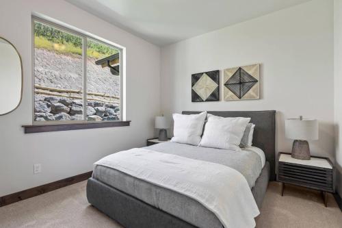 a white bedroom with a bed and a window at Black Rock Ridge 14488 by Moose Management in Park City
