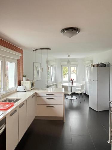 uma cozinha com um frigorífico branco e uma mesa em Fantástica Casa Barco em Pechón