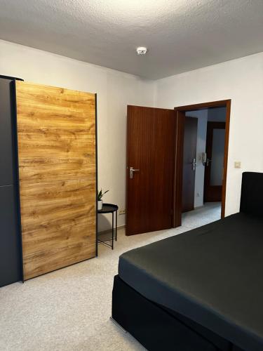 Schlafzimmer mit einer großen Holztür und einem Bett in der Unterkunft Hansestraße in Lübeck