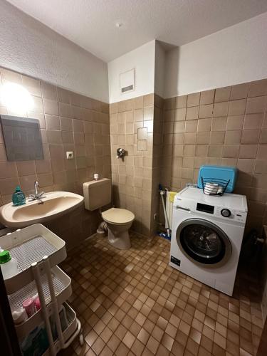 ein Badezimmer mit einer Waschmaschine und einem Waschbecken in der Unterkunft Hansestraße in Lübeck
